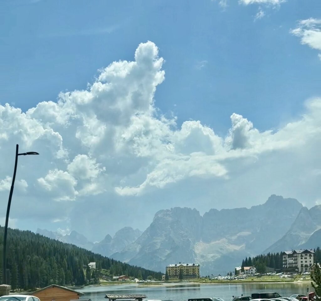 Passeggiata facile di circa 2,7 km, cosa vedere, dove parcheggiare e come abbinarla al Lago di Sorapis.
Il Lago di Misurina si trova a pochi minuti da Passo Tre Croci, praticamente sulla strada del ritorno da chi visita il Lago di Sorapis. Noi abbiamo visitato il Lago di Misurina al rientro dal trekking al Lago di Sorapis. Se state pensando di fare entrambe le tappe, trovate qui la nostra esperienza sul sentiero 215.
📌 In breve
🚶 Passeggiata pianeggiante di circa 2,7 km intorno al lago
⏱ Circa 40 minuti per il giro completo (noi ci siamo fermati un'ora)
🚗 Parcheggio a pagamento, diversi lungo le rive del lago
👨‍👩‍👧 Adatta a tutti, anche con passeggino
📍 Comodo da abbinare al Lago di Sorapis, essendo a pochi minuti di distanza
Dove si trova e come arrivare
Il Lago di Misurina si trova a 1.754 metri, nella frazione di Misurina (comune di Auronzo di Cadore, provincia di Belluno), tra Cortina d'Ampezzo e la Val Pusteria, a pochi chilometri da Passo Tre Croci. È un punto strategico delle Dolomiti orientali: da qui parte anche la celebre strada a pedaggio per le Tre Cime di Lavaredo.
Vista la vicinanza, è la tappa ideale da abbinare a un'escursione al Lago di Sorapis, magari fermandosi qui al ritorno, come abbiamo fatto noi.
📷 [Foto: il Lago di Misurina]
Il parcheggio
I parcheggi pubblici intorno al Lago di Misurina sono a pagamento nel periodo dal 15 maggio al 31 ottobre, dalle 8:00 alle 20:00. Le tariffe possono variare in base all'area; per le autovetture, le tariffe comunali indicano 2€ all'ora oppure 14€ per l'intera giornata. Controllate comunque sempre il cartello del parcheggio scelto prima di lasciare l'auto.
Nota: a sud del lago si trova anche il parcheggio della seggiovia Col de Varda, riservato a chi usa l'impianto — non lasciateci l'auto se il vostro obiettivo è solo la passeggiata intorno al lago.
📷 [Foto: il parcheggio con le tariffe]
La passeggiata intorno al lago
Il giro completo del Lago di Misurina è una passeggiata facile di circa 2,7 km, quasi completamente pianeggiante, che richiede circa 40 minuti. È adatta anche alle famiglie e, secondo le descrizioni dei percorsi disponibili, può essere affrontata anche con il passeggino. Lungo il percorso si aprono scorci panoramici sempre diversi sulle montagne circostanti, con panchine e aree di sosta dove fermarsi ad ammirare il paesaggio.
Noi ci siamo fermati circa un'ora, camminando con calma e facendo diverse soste per fotografare il panorama.
📷 [Foto: il sentiero intorno al lago] 📷 [Foto di famiglia al lago]
Perché abbinarlo al Lago di Sorapis
Se dopo il trekking al Lago di Sorapis cercate una passeggiata molto più tranquilla, potete fermarvi al vicino Lago di Misurina, come abbiamo fatto noi al rientro. Essendo praticamente sulla stessa strada, permette di chiudere la giornata con un ritmo più rilassato dopo la fatica del trekking più impegnativo della mattina.
I nostri consigli
Controllate bene le tariffe del parcheggio scelto: variano da zona a zona intorno al lago
Se possibile, arrivate presto al mattino o nel tardo pomeriggio: in alta stagione (luglio-agosto) i parcheggi si riempiono in fretta
Non lasciate l'auto nel parcheggio della seggiovia Col de Varda se non salite con l'impianto
La balneazione non è consentita: il lago si gode passeggiando lungo le sue sponde
Vale la pena fermarsi?
Sì, soprattutto se siete già in zona per un'altra escursione. Non è una meta che richiede una giornata intera, ma una sosta breve e piacevole, perfetta per chiudere una giornata più impegnativa con un ritmo più tranquillo.
Domande frequenti sul Lago di Misurina
Quanto dura il giro del Lago di Misurina? Circa 40 minuti per il percorso completo di 2,7 km, pianeggiante. Noi ci siamo fermati circa un'ora con calma.
Il parcheggio al Lago di Misurina è a pagamento? Sì, dal 15 maggio al 31 ottobre, dalle 8:00 alle 20:00. Le tariffe comunali indicano 2€ all'ora o 14€ per l'intera giornata, ma possono variare in base all'area — controllate sempre il cartello del parcheggio scelto.
Si può fare il bagno nel Lago di Misurina? No, la balneazione non è consentita.
Il Lago di Misurina è vicino al Lago di Sorapis? Sì, si trova a pochi minuti da Passo Tre Croci, punto di partenza per il Lago di Sorapis: è comodo abbinarli nella stessa giornata.
Il percorso è adatto ai bambini? Sì, è una passeggiata pianeggiante e semplice, percorribile anche con il passeggino.
📷 [Foto finale: il Lago di Misurina]
Se state organizzando un viaggio nelle Dolomiti, il Lago di Misurina è una tappa comoda da abbinare al Lago di Sorapis. Leggete anche le nostre guide sul Lago di Braies, sul Lago di Carezza e sull'Alpe di Siusi, oppure la nostra guida sulle Dolomiti più belle da vedere almeno una volta per organizzare il viaggio completo.